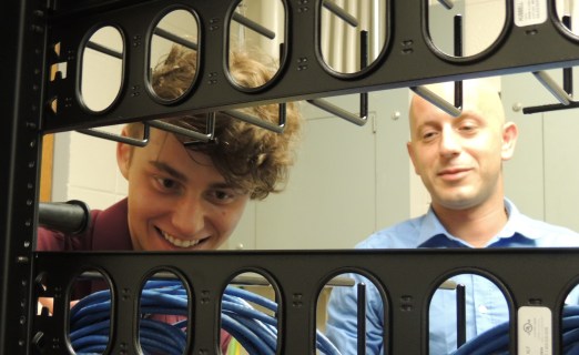Network infrastructure major Cody Arnold (left) traces cables on a cable management rack to comply with Ivy Tech Northeast standards, as Alexander Jovanovich, an associate network engineer at the College and Arnold’s internship supervisor, oversees his progress. Arnold recently achieved first place in the 2015 Cisco  Certified Entry Networking Technician, or CCENT, competition among 170 high school, college, and university participants from the United States and Canada.