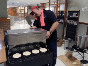 Trevor Muir, of Chris Cakes, uses a machine with four spouts to dispense batter onto the grill.