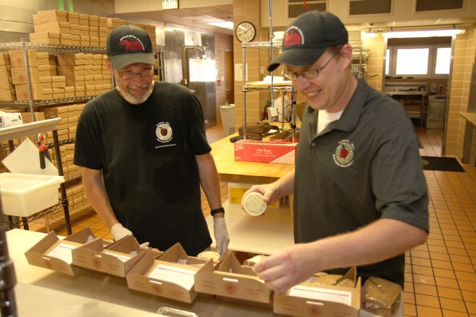 Apple Spice Junction employee Paul Hazelton (left) observes general manager Nate Getts as he packages gourmet boxed lunches. Apple Spice Junction is an affirmative business that employs Park Center clients who have recovered from major mental illness and been out of the workforce for an extended period of time. Following six months of job training from Getts, Hazelton will seek a long-term employment opportunity elsewhere in the community.
