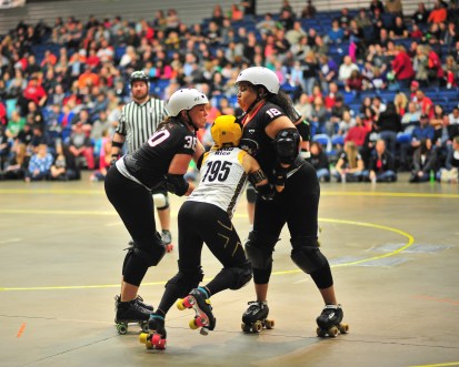 Salyers, at left, plays a blocker with the Fort Wayne Derby Girls. Blockers try to prevent the other team‘s jammer from scoring. Jammers are denoted by the star on their helmet, seen on the middle skater.