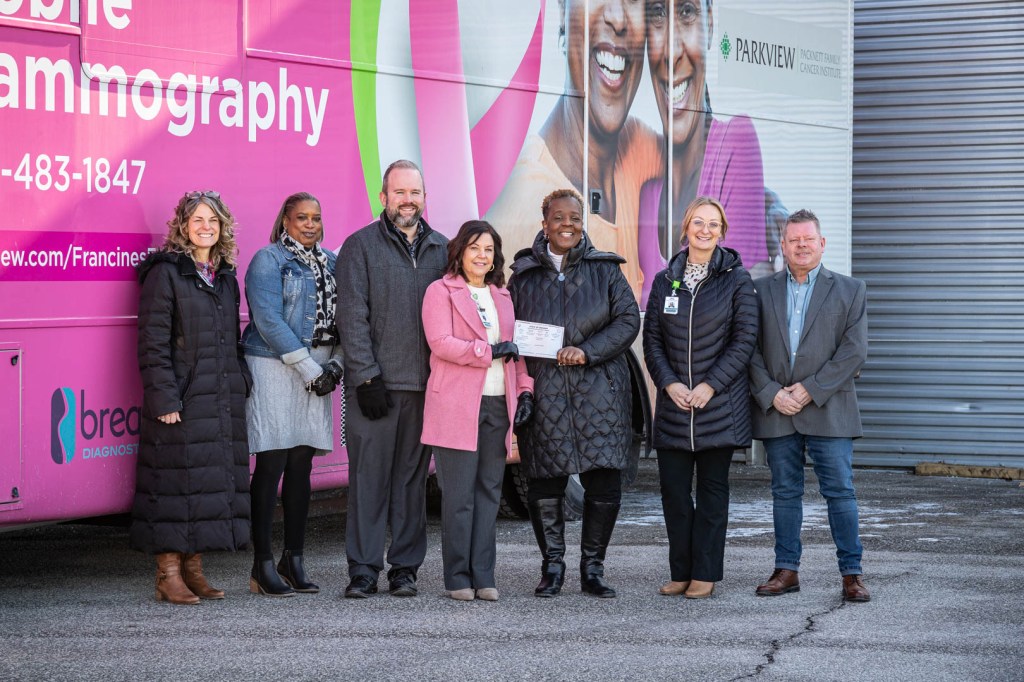 Officials from Ivy Tech Fort Wayne and Parkview Health in front of bus donation